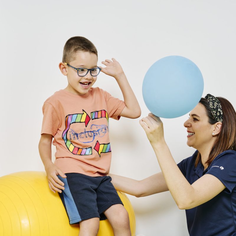 terapeuta jugando con un niño para la fisioterapia