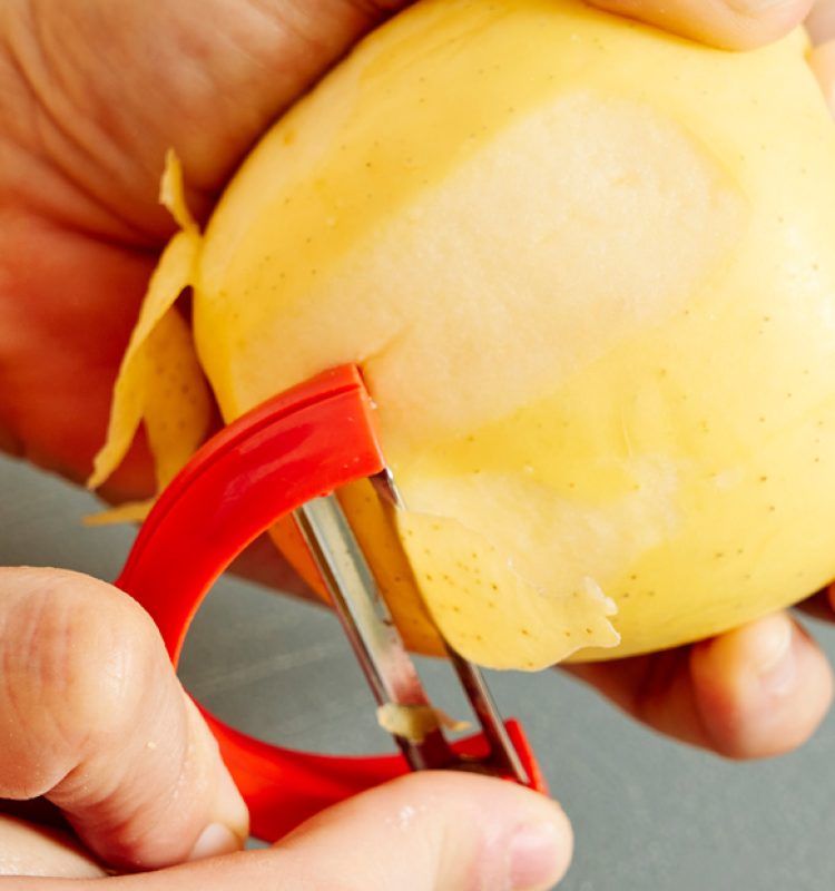 mujer adulta quitando la piel de una manzana