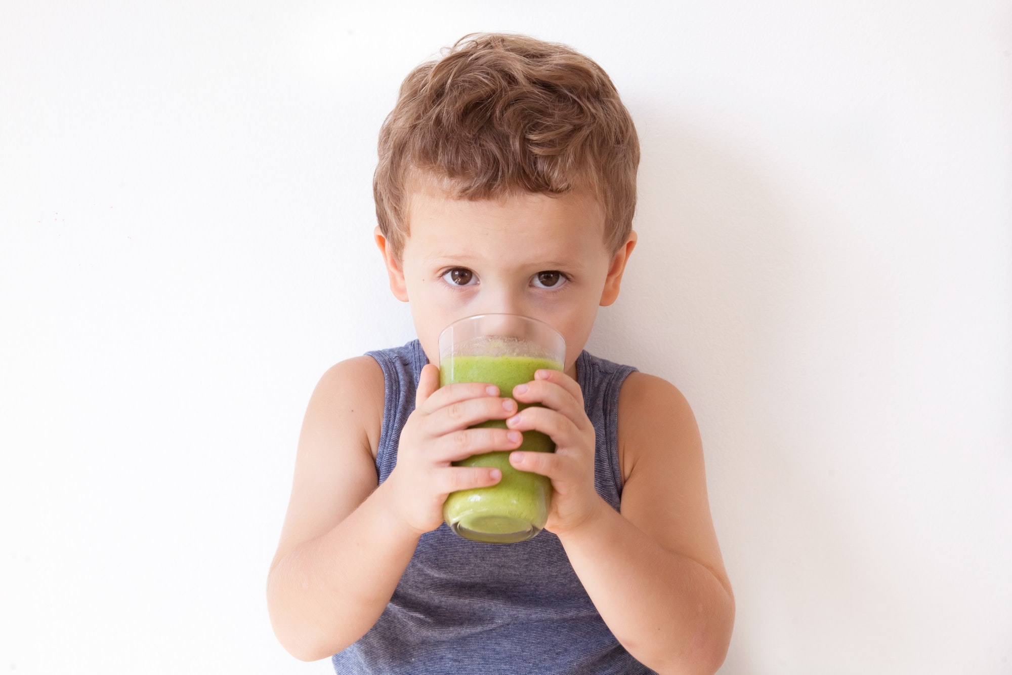 Healthy food food kids. Happy boy drinking green smoothie cocktail